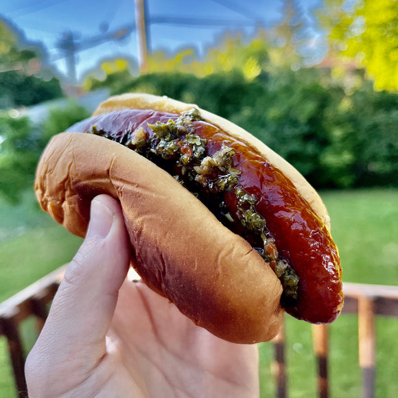 Choripan. Chorizo sausage in a bun with chimichurri sauce.