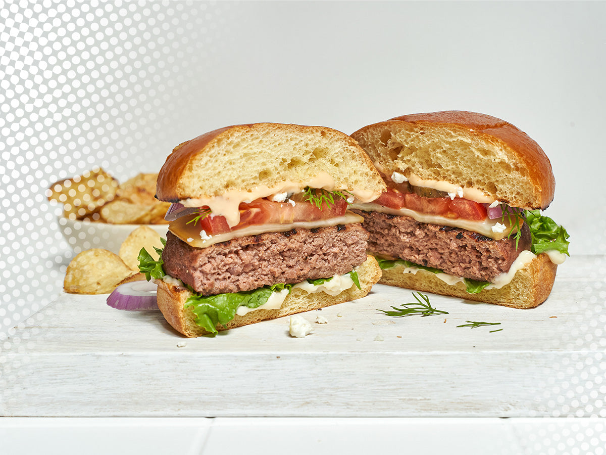 Close Up of Bump Burger Assembled with Bowl of Chips in Background